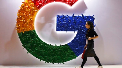 A woman walks past the Google logo at the China International Import Expo in Shanghai, Nov. 5, 2018.
