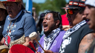 Jesse Barrientez, aka Red Feather, center, plays the drums and sings tribal songs with other Indigenous people during a march, Clearwater County, Minn., June 7, 2021.
