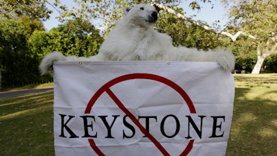 A member of the Center for Biological Diversity, in polar bear costume, protests the Keystone XL pipeline during a visit by then-President Barack Obama to Los Angeles, May 7, 2014.