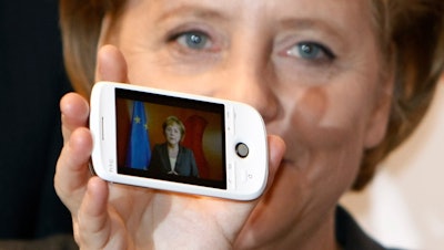 German Chancellor Angela Merkel holds a cell phone at the CeBIT in Hanover, March 3, 2009.