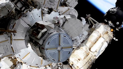 In this image taken from NASA video, French astronaut Thomas Pesquet, top center, and NASA astronaut Shane Kimbrough venture out on a spacewalk, June 16, 2021.