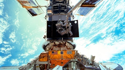 Astronauts Steven L. Smith and John M. Grunsfeld are photographed during an extravehicular activity during the December 1999 Hubble servicing mission of STS-103.