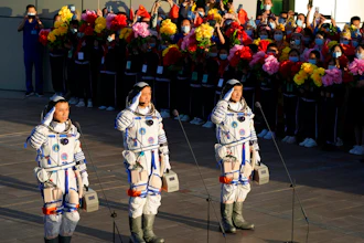 Chinese astronauts, from left, Tang Hongbo, Nie Haisheng, and Liu Boming salute as they prepare to board for liftoff at the Jiuquan Satellite Launch Center, June 17, 2021.