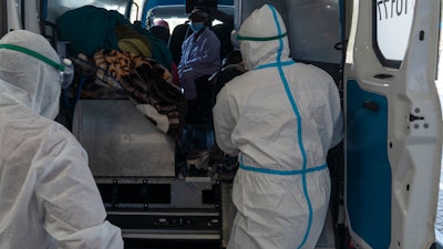 Health workers arrive with a patient at the Chris Hani Baragwanath Academic Hospital's COVID-19 facility, Johannesburg, June 21, 2021.