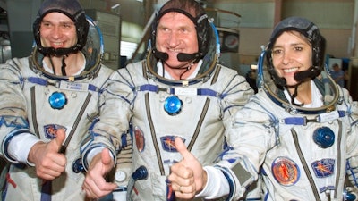 French astronaut Claudie Haignere, right, and her Russian crewmates Viktor Afanasyev, center, and Konstantin Kozeyev train inside the mock-up of a Soyuz TM spacecraft in Star City, July 5, 2001.