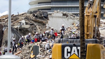 Search and rescue personnel search for survivors through the rubble at the Champlain Towers South Condo, Surfside, Fla., June 25, 2021.