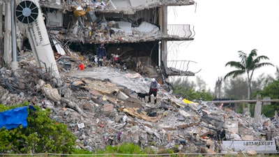 The South Florida Urban Search and Rescue team looks through rubble for survivors at the partially collapsed Champlain Towers South condo building in Surfside, Fla., June 28, 2021.