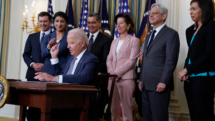 President Joe Biden hands out a pen after signing an executive order in the State Dining Room of the White House, July 9, 2021.
