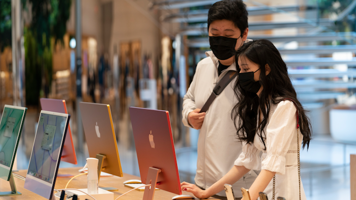 Customers view iMac computers in an Apple store, New York, May 21, 2021.