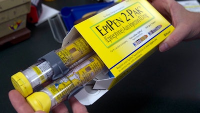 A pharmacist holds a package of EpiPen epinephrine auto-injectors in Sacramento, Calif., July 8, 2016.