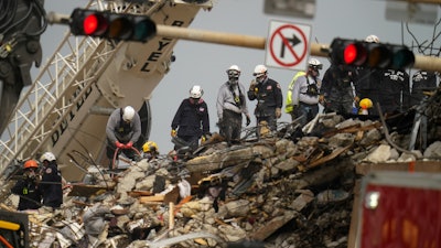 Search and rescue personnel work atop the rubble at the Champlain Towers South condo building, Surfside, Fla., June 30, 2021.