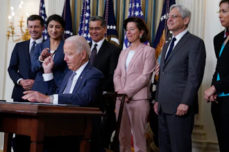 President Joe Biden hands out a pen after signing an executive order in the State Dining Room of the White House, July 9, 2021.