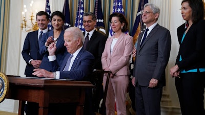 President Joe Biden hands out a pen after signing an executive order in the State Dining Room of the White House, July 9, 2021.