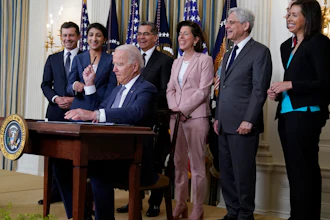 President Joe Biden hands out a pen after signing an executive order, State Dining Room, White House, July 9, 2021.