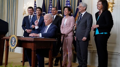 President Joe Biden hands out a pen after signing an executive order, State Dining Room, White House, July 9, 2021.