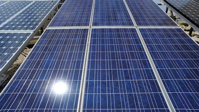 Sunlight reflects off solar panels on the roof of the older part of the Alabama Power building in Birmingham, Ala., Aug. 9, 2012.