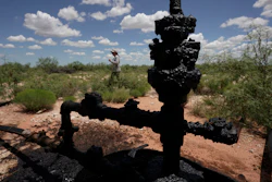 Ashley Williams Watt walks near a wellhead and flowline at her ranch near Crane, Texas, July 9, 2021.