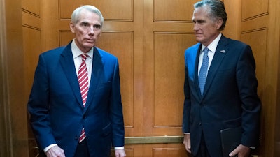 Sen. Rob Portman, R-Ohio, left, and Sen. Mitt Romney, R-Utah, leave in the elevator after a closed door talks about infrastructure on Capitol Hill, July 15, 2021.