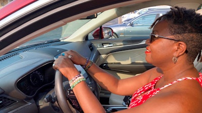 Jessica Pitts sits behind the wheel of a 2019 Lincoln MKC on the lot of Jack Demmer Lincoln in Dearborn, Mich., July 19, 2021.