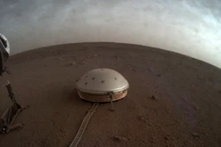 Clouds drift over the dome-covered SEIS seismometer of the InSight lander on the surface of Mars.