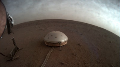 Clouds drift over the dome-covered SEIS seismometer of the InSight lander on the surface of Mars.