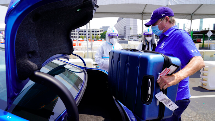An Uber driver loads luggage at Los Angeles International Airport, Aug. 20, 2020.