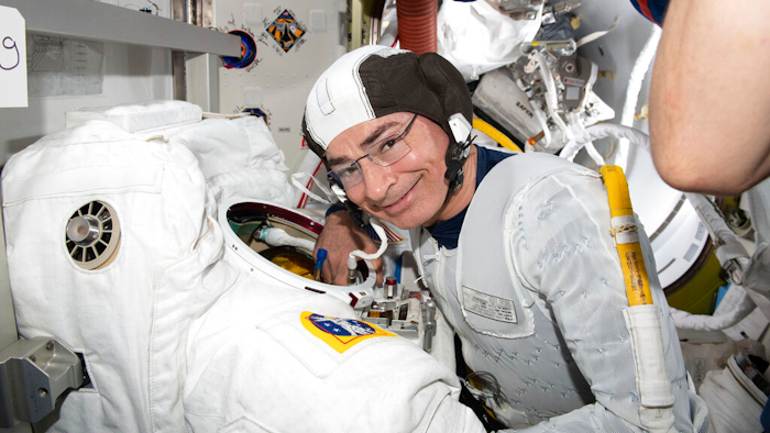 Astronaut and Expedition 65 Flight Engineer Mark Vande Hei inspects a spacesuit in preparation for a spacewalk at the International Space Station, Aug. 17, 2021.