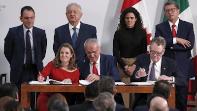 Deputy Prime Minister of Canada Chrystia Freeland, left, Mexico's top trade negotiator Jesus Seade, center, and U.S. Trade Representative Robert Lighthizer, sign an update to the North American Free Trade Agreement,at the national palace in Mexico City, Dec. 10. 2019.