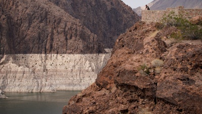A person looks out over Lake Mead near Hoover Dam at the Lake Mead National Recreation Area in Arizona, Aug. 13, 2021.