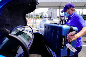 An Uber driver loads luggage at Los Angeles International Airport, Aug. 20, 2020.