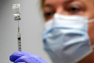 Pharmacy technician Hollie Maloney loads a syringe with Pfizer's COVID-19 vaccine at the Portland Expo in Portland, Maine, March 2, 2021.