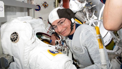 Astronaut and Expedition 65 Flight Engineer Mark Vande Hei inspects a spacesuit in preparation for a spacewalk at the International Space Station, Aug. 17, 2021.