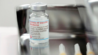 A Moderna COVID-19 vaccine vial is administered for flight attendants of Japan Airlines, Haneda Airport, Tokyo, June 14, 2021.