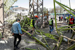Construction workers observe the wreckage after a crane collapsed at a construction project to build a 14-storey student hostel in Nairobi, Kenya Thursday, Aug. 26, 2021. Police in Kenya's capital say nine people are dead, including two Chinese engineers, after the crane collapsed at the site being supervised by a Chinese construction firm.