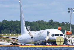 In this May 4, 2019, file photo, a charter plane carrying 143 people and traveling from Cuba to north Florida sits in a river at the end of a runway in Jacksonville, Fla. Investigators say the loss of braking power on a rain-soaked flooded runway caused a cargo plane chartered by the Pentagon to slide into a Florida river in 2019, the National Transportation Safety Board said Wednesday, AUg. 4, 2021.