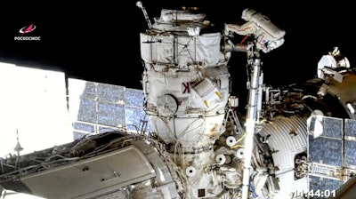 In this image taken from Roscosmos video, Russian cosmonauts Oleg Novitsky, top, and Pyotr Dubrov, bottom, perform a spacewalk to replace old batteries outside the International Space Station, June 2, 2021.