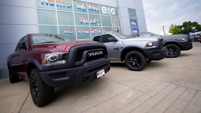 Unsold 2021 Ram pickup trucks parked on the storage lot outside a Ram dealership, Littleton, Colo., Aug. 29, 2021.