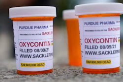 Fake pill bottles with messages about OxyContin maker Purdue Pharma displayed outside the courthouse in White Plains, N.Y., Aug. 9, 2021.