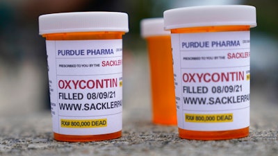 Fake pill bottles with messages about OxyContin maker Purdue Pharma displayed outside the courthouse in White Plains, N.Y., Aug. 9, 2021.