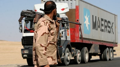 A private security contractor watches a NATO supply truck in the province of Ghazni, Afghanistan, Oct. 27, 2010.