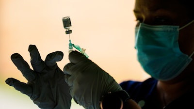 A syringe is prepared with the Pfizer COVID-19 vaccine at a clinic at the Reading Area Community College in Reading, Pa., Sept. 14, 2021.