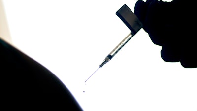 A droplet falls from a syringe after a person was injected with the Pfizer COVID-19 vaccine at a hospital in Providence, R.I., Dec. 15, 2020.