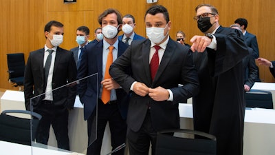 Paulo Richardo Rocha Pinto, husband of a victim, lawyer Pedro Martins, Gustavo Barroso Camara, brother of a victim, and lawyer Jan Erik Spangenberg, from left, arrive at the Munich Regional Court , Sept. 28, 2021.