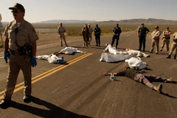 In this May 11, 2003, file photo, protesters lie on the pavement opposed to the proposed Yucca Mountain nuclear storage facility and weapons testing after crossing the line into the Nevada Test Site at Mercury, Nev., and were arrested for trespassing about 70 miles north of Las Vegas. A bipartisan group of lawmakers is renewing the push to expand a federal compensation program for radiation exposure following uranium mining and nuclear testing carried out during the Cold War.