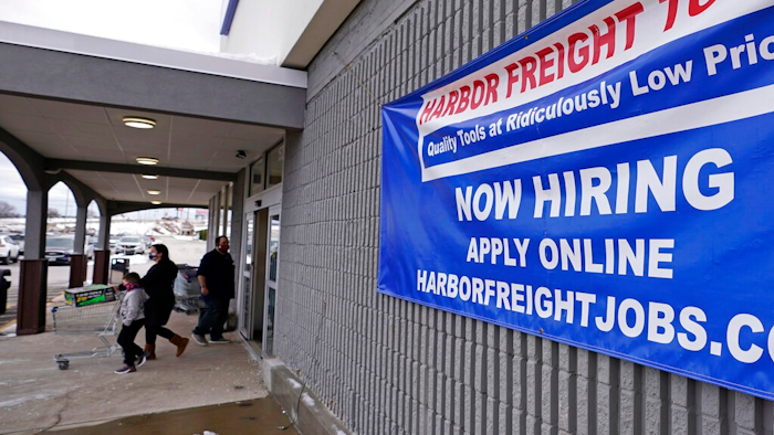 In this Dec. 10, 2020, file photo, a 'Now Hiring' sign hangs on the front wall of a Harbor Freight Tools store in Manchester, N.H. When the U.S. government issues the September jobs report on Friday, Oct. 8, 2021, the spotlight will fall not only on how many people were hired last month. A second question will command attention, too: Are more people finally starting to look for work?