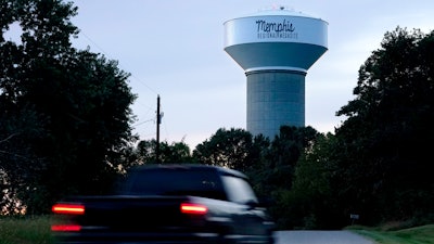 A truck drives down a rural road near a water tower marking the location of the Memphis Regional Megasite, Sept. 24, 2021, Stanton, Tenn.