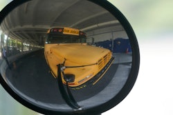 A diesel-powered school bus is reflected in a mirror at MAST Academy, Miami, Sept. 29, 2021.