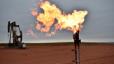 A flare burns natural gas at an oil well, Aug. 26, 2021, Watford City, N.D.