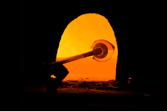 A glass worker heats glass in a methane-powered oven in a factory in Murano island, Venice, Italy, Oct. 7, 2021.