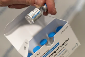 A pharmacist holds a vial of the Johnson & Johnson COVID-19 vaccine at a hospital in Bay Shore, N.Y., March 3, 2021.
